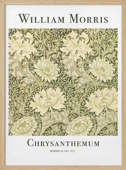 A framed art print of William Morris's 'Chrysanthemum' pattern from 1877. The design features a dense, repeating pattern of large, cream-colored chrysanthemums and foliage in shades of sage green on a dark green background. The poster has a white border with the artist's name at the top and the title at the bottom. Print