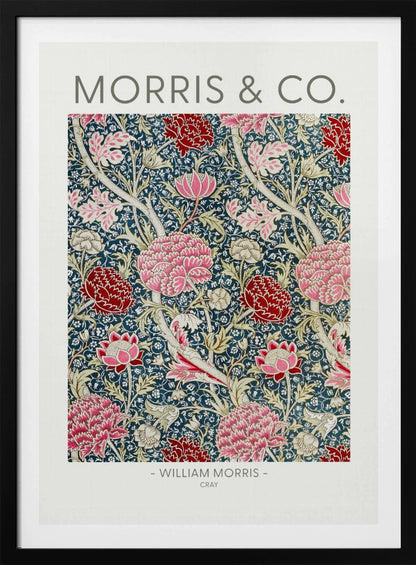 A framed art print of William Morris's 'Cray' pattern, featuring a dense floral design with large pink and red stylized flowers and foliage on a dark navy blue background. The text 'MORRIS & CO.' is above the pattern, and '- WILLIAM MORRIS - CRAY' is below. Artwork