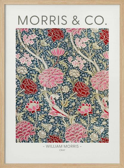A framed art print of William Morris's 'Cray' pattern, featuring a dense floral design with large pink and red stylized flowers and foliage on a dark navy blue background. The text 'MORRIS & CO.' is above the pattern, and '- WILLIAM MORRIS - CRAY' is below. Artwork