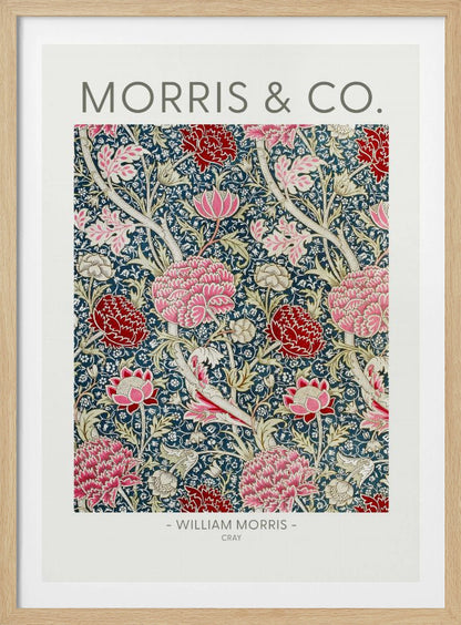 A framed art print of William Morris's 'Cray' pattern, featuring a dense floral design with large pink and red stylized flowers and foliage on a dark navy blue background. The text 'MORRIS & CO.' is above the pattern, and '- WILLIAM MORRIS - CRAY' is below. Artwork