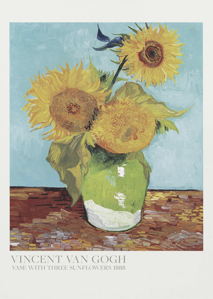 A framed art print of Vincent van Gogh's painting 'Vase with Three Sunflowers' from 1888. The artwork features three large, vibrant yellow sunflowers in a green vase set against a textured light blue background. The painting is in the post-impressionist style with thick, visible brushstrokes. The print has a white border with text at the bottom identifying the artist and title. Print