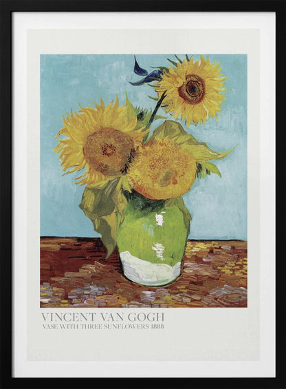 A framed art print of Vincent van Gogh's painting 'Vase with Three Sunflowers' from 1888. The artwork features three large, vibrant yellow sunflowers in a green vase set against a textured light blue background. The painting is in the post-impressionist style with thick, visible brushstrokes. The print has a white border with text at the bottom identifying the artist and title. Print
