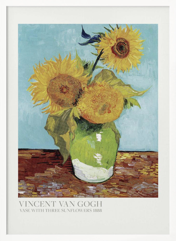A framed art print of Vincent van Gogh's painting 'Vase with Three Sunflowers' from 1888. The artwork features three large, vibrant yellow sunflowers in a green vase set against a textured light blue background. The painting is in the post-impressionist style with thick, visible brushstrokes. The print has a white border with text at the bottom identifying the artist and title. Print