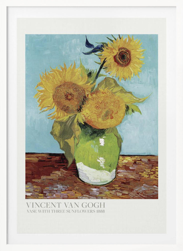 A framed art print of Vincent van Gogh's painting 'Vase with Three Sunflowers' from 1888. The artwork features three large, vibrant yellow sunflowers in a green vase set against a textured light blue background. The painting is in the post-impressionist style with thick, visible brushstrokes. The print has a white border with text at the bottom identifying the artist and title. Print