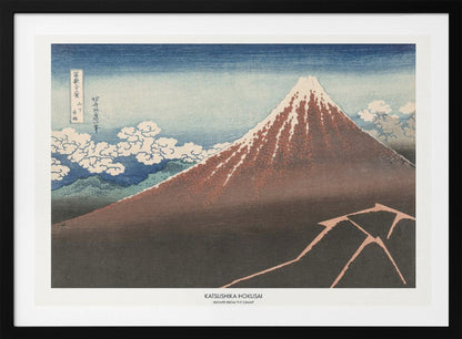 A framed Japanese woodblock print by Katsushika Hokusai titled 'Shower Below the Summit.' The print depicts a large, dark brown and reddish mountain, likely Mount Fuji, with a snow-capped peak. The sky above is a deep blue, and stylized white clouds are scattered around the mountain's slope. In the dark foreground, a jagged pink line represents a lightning strike. Artwork