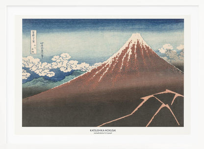 A framed Japanese woodblock print by Katsushika Hokusai titled 'Shower Below the Summit.' The print depicts a large, dark brown and reddish mountain, likely Mount Fuji, with a snow-capped peak. The sky above is a deep blue, and stylized white clouds are scattered around the mountain's slope. In the dark foreground, a jagged pink line represents a lightning strike. Artwork