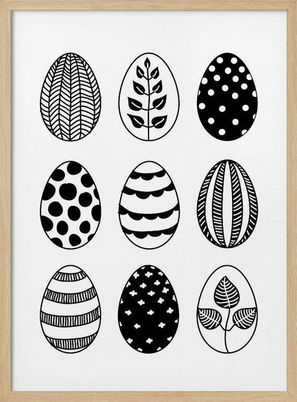 A black and white art print featuring a 3x3 grid of nine illustrated Easter eggs. Each egg has a unique, hand-drawn pattern, including polka dots, stripes, chevrons, florals, and leafy branches, all within a thin black frame. Poster