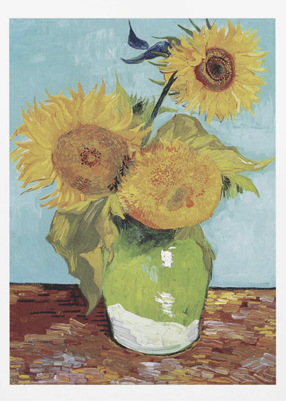 A framed reproduction of Vincent van Gogh's famous 'Sunflowers' painting, featuring three large yellow sunflowers in a green vase against a light blue background, painted in his iconic post-impressionist style with thick brushstrokes. Wall Art