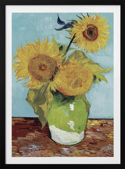 A framed reproduction of Vincent van Gogh's famous 'Sunflowers' painting, featuring three large yellow sunflowers in a green vase against a light blue background, painted in his iconic post-impressionist style with thick brushstrokes. Wall Art