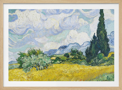 A framed print of Vincent van Gogh's painting 'Wheat Field with Cypresses.' The artwork depicts a vibrant golden wheat field under a dynamic sky filled with swirling white and blue clouds. A tall, dark green cypress tree dominates the right side, with rolling green hills and distant blue mountains in the background. Decor