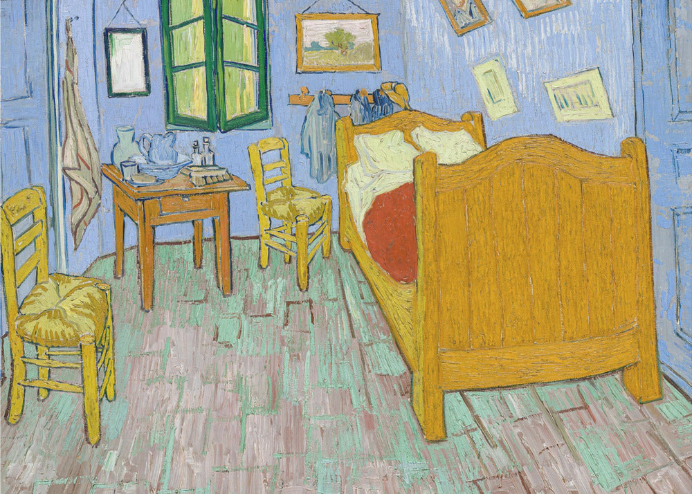 Vincent van Gogh's famous painting, 'The Bedroom,' depicting his room in Arles. The artwork, characterized by bold colors and expressive brushstrokes, features a yellow wooden bed, chairs, a small table against light blue walls, and a green-shuttered window. The painting is displayed in a simple silver frame. Decor
