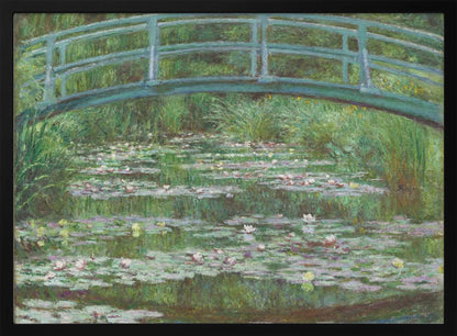 An Impressionist painting by Claude Monet depicting a green Japanese-style footbridge arching over a tranquil pond filled with blooming water lilies and lily pads, all rendered in soft, dappled brushstrokes and framed in a modern silver frame. Print