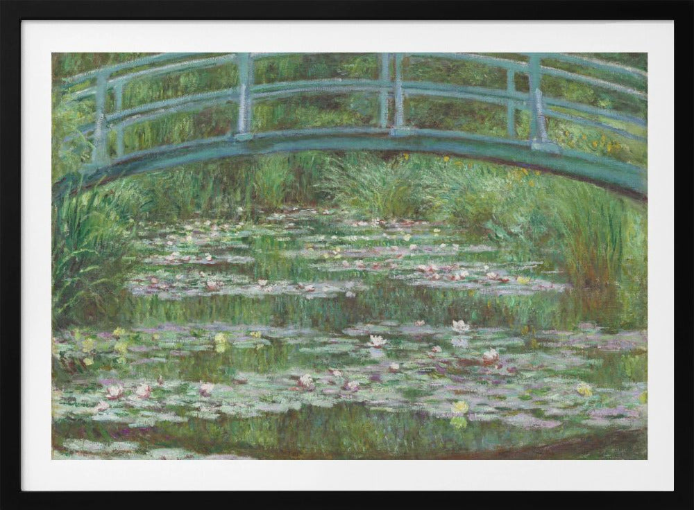 An Impressionist painting by Claude Monet depicting a green Japanese-style footbridge arching over a tranquil pond filled with blooming water lilies and lily pads, all rendered in soft, dappled brushstrokes and framed in a modern silver frame. Print