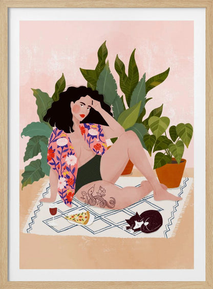 An illustration of a woman with dark curly hair relaxing on a patterned blanket indoors. She is wearing a green swimsuit and a pink floral shirt, with a prominent snake tattoo on her thigh. Next to her is a slice of pizza, a glass of red wine, and a sleeping black and white cat, all set against a backdrop of large green houseplants and a pink wall. Artwork