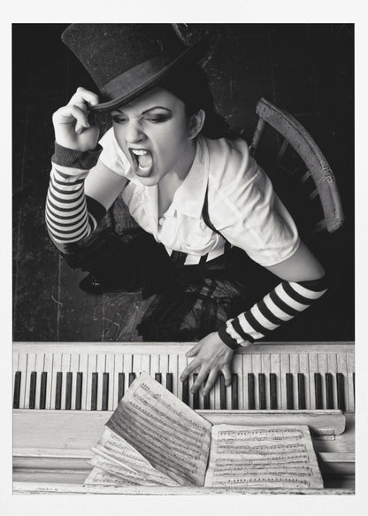 A dramatic black and white high-angle photograph of a woman in a top hat and striped arm warmers, shouting or singing passionately while seated at a piano with sheet music. Print