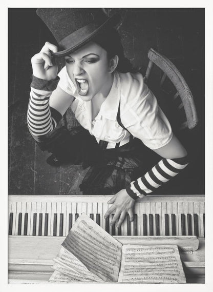 A dramatic black and white high-angle photograph of a woman in a top hat and striped arm warmers, shouting or singing passionately while seated at a piano with sheet music. Print