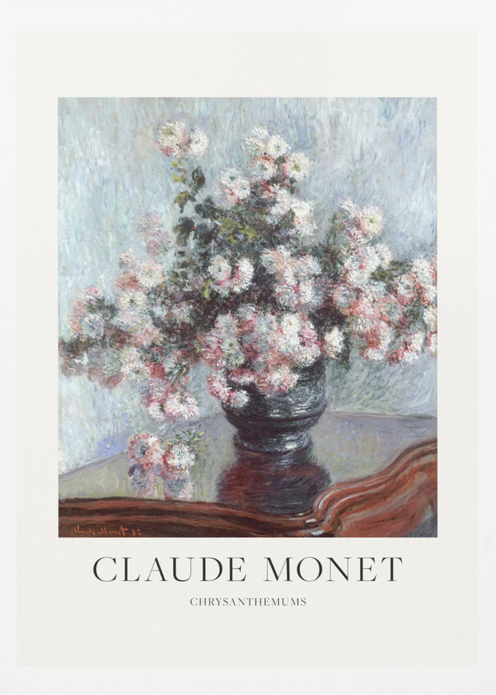 A framed art print of Claude Monet's impressionist painting, 'Chrysanthemums.' The painting features a lush bouquet of pink and white chrysanthemums in a dark vase resting on a reflective, mahogany-colored table against a light blue, textured background. The print includes a white border with the artist's name and the title below the artwork, all enclosed in a simple black frame. Print