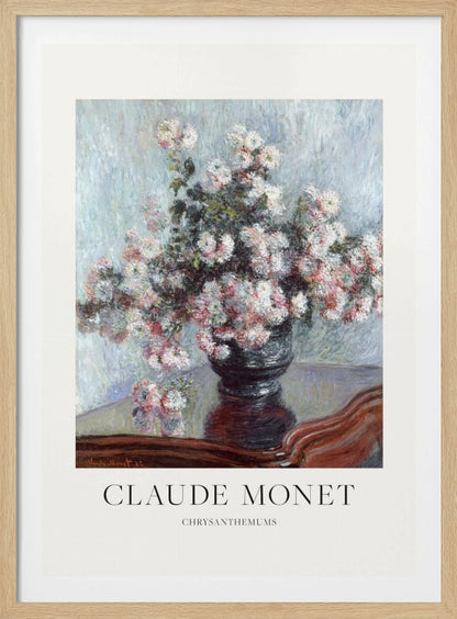 A framed art print of Claude Monet's impressionist painting, 'Chrysanthemums.' The painting features a lush bouquet of pink and white chrysanthemums in a dark vase resting on a reflective, mahogany-colored table against a light blue, textured background. The print includes a white border with the artist's name and the title below the artwork, all enclosed in a simple black frame. Print