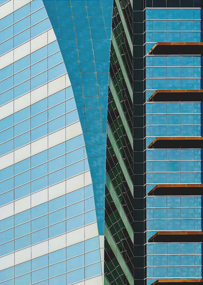 An abstract close-up photograph of modern skyscrapers, featuring a dynamic composition of intersecting lines and geometric patterns. The facades consist of blue, white, and dark green reflective glass, creating a visually complex play of light, shadow, and color. Wall Art