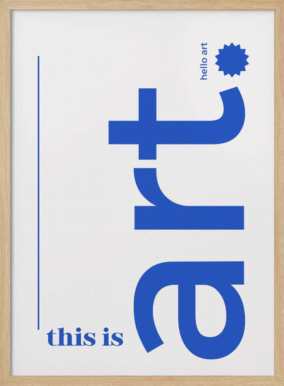 A minimalist art print in a black frame, featuring a white background with blue text. The word 'art' is written vertically in a large, bold lowercase font. To the left, smaller text reads 'this is'. At the top right, 'hello art' is written next to a blue starburst graphic. Wall Art