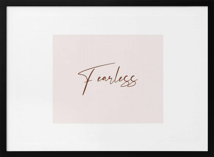 A framed artwork featuring the word 'Fearless' in a flowing brown script font on a pale pink background. The piece is surrounded by a white mat and a textured silver frame. Wall Art