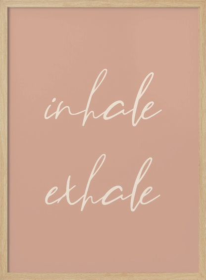 A minimalist framed poster featuring the words 'inhale' and 'exhale' in a flowing white script font, stacked vertically against a solid dusty pink background. Poster