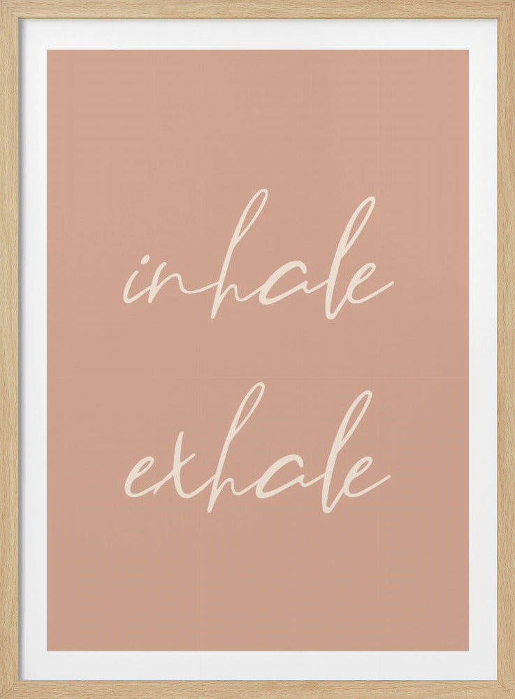 A minimalist framed poster featuring the words 'inhale' and 'exhale' in a flowing white script font, stacked vertically against a solid dusty pink background. Poster