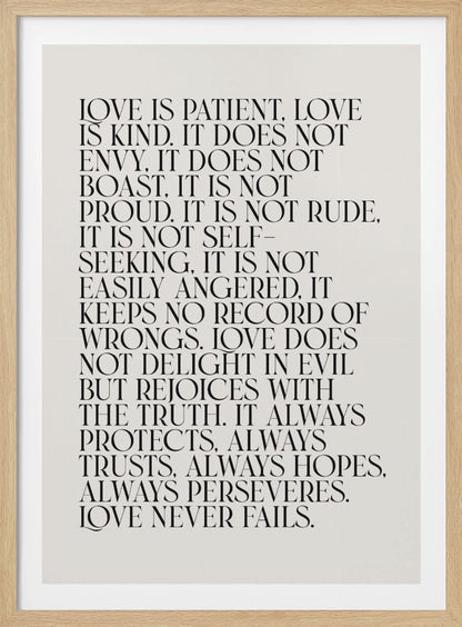 A minimalist art print featuring the 'Love is patient, love is kind...' bible verse from 1 Corinthians 13. The text is printed in a black, all-caps serif font on an off-white background and is surrounded by a simple black frame. Print