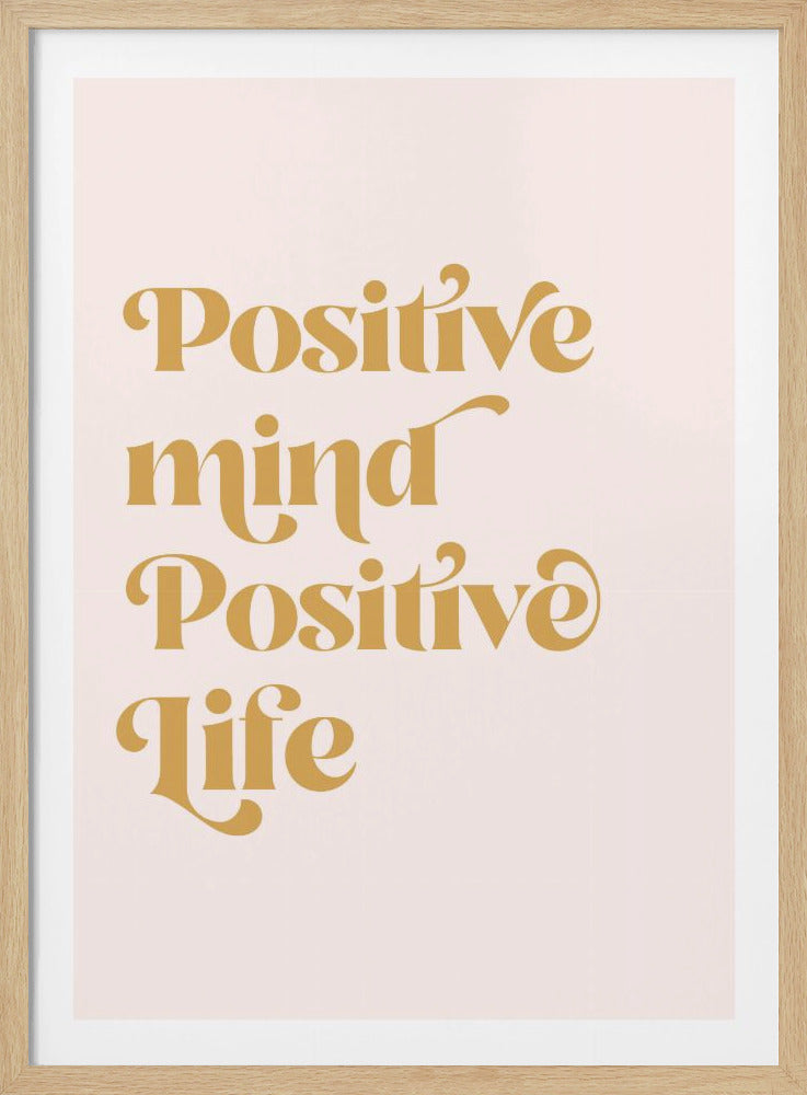 A framed art print featuring the motivational quote 'Positive mind Positive life' in a gold, retro-style font against a light pink background. The text is centered and arranged vertically. Artwork
