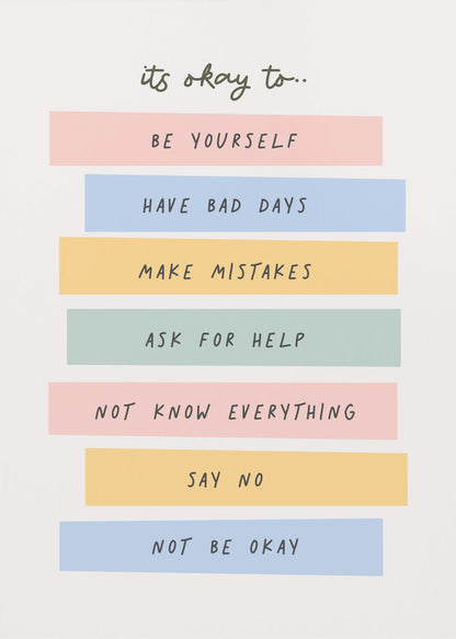 A framed inspirational poster with a white background. At the top, in a black handwritten font, it says 'it's okay to...'. Below is a list of affirmations, each on a different colored pastel rectangle: 'BE YOURSELF' on pink, 'HAVE BAD DAYS' on blue, 'MAKE MISTAKES' on yellow, 'ASK FOR HELP' on green, 'NOT KNOW EVERYTHING' on pink, 'SAY NO' on yellow, and 'NOT BE OKAY' on blue. Poster