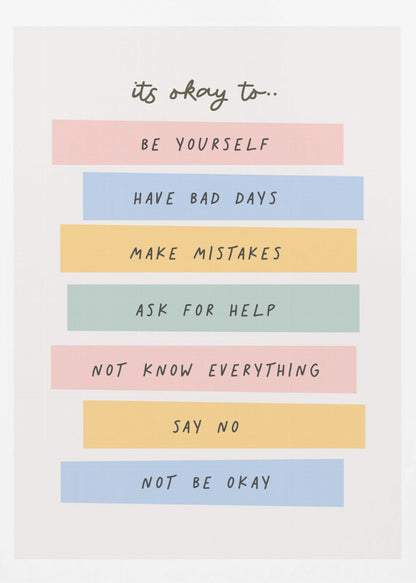 A framed inspirational poster with a white background. At the top, in a black handwritten font, it says 'it's okay to...'. Below is a list of affirmations, each on a different colored pastel rectangle: 'BE YOURSELF' on pink, 'HAVE BAD DAYS' on blue, 'MAKE MISTAKES' on yellow, 'ASK FOR HELP' on green, 'NOT KNOW EVERYTHING' on pink, 'SAY NO' on yellow, and 'NOT BE OKAY' on blue. Poster