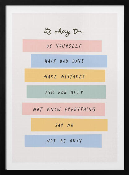 A framed inspirational poster with a white background. At the top, in a black handwritten font, it says 'it's okay to...'. Below is a list of affirmations, each on a different colored pastel rectangle: 'BE YOURSELF' on pink, 'HAVE BAD DAYS' on blue, 'MAKE MISTAKES' on yellow, 'ASK FOR HELP' on green, 'NOT KNOW EVERYTHING' on pink, 'SAY NO' on yellow, and 'NOT BE OKAY' on blue. Poster