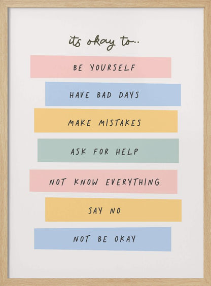 A framed inspirational poster with a white background. At the top, in a black handwritten font, it says 'it's okay to...'. Below is a list of affirmations, each on a different colored pastel rectangle: 'BE YOURSELF' on pink, 'HAVE BAD DAYS' on blue, 'MAKE MISTAKES' on yellow, 'ASK FOR HELP' on green, 'NOT KNOW EVERYTHING' on pink, 'SAY NO' on yellow, and 'NOT BE OKAY' on blue. Poster