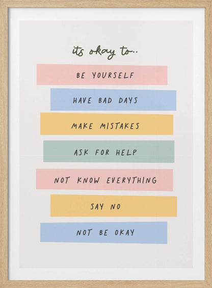 A framed inspirational poster with a white background. At the top, in a black handwritten font, it says 'it's okay to...'. Below is a list of affirmations, each on a different colored pastel rectangle: 'BE YOURSELF' on pink, 'HAVE BAD DAYS' on blue, 'MAKE MISTAKES' on yellow, 'ASK FOR HELP' on green, 'NOT KNOW EVERYTHING' on pink, 'SAY NO' on yellow, and 'NOT BE OKAY' on blue. Poster