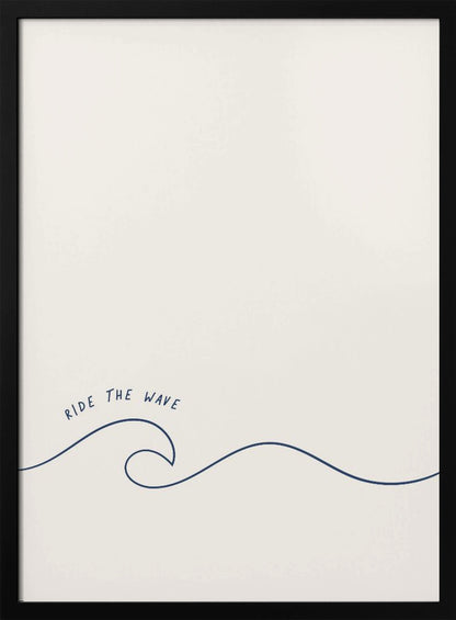 A minimalist art print in a black frame featuring a single dark blue line that forms a simple ocean wave on an off-white background. The words 'RIDE THE WAVE' are written in a casual, handwritten font above the crest. Wall Art