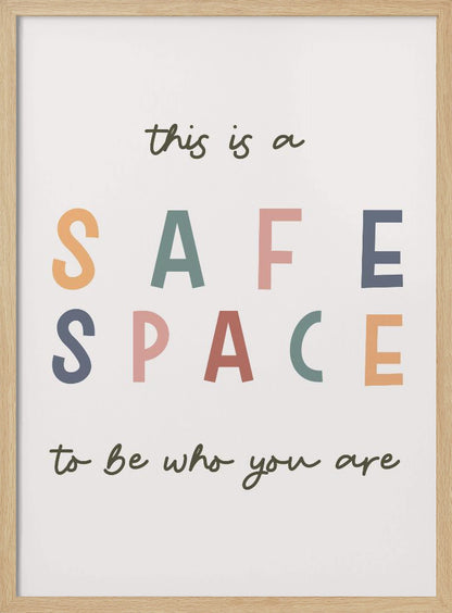 A framed poster with an inspirational message that reads 'this is a SAFE SPACE to be who you are'. The words 'SAFE SPACE' are in large, block letters of various muted colors like orange, sage, pink, and blue, while the rest of the text is in a smaller, dark green script font on an off-white background. Poster