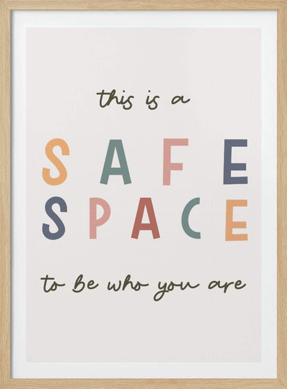 A framed poster with an inspirational message that reads 'this is a SAFE SPACE to be who you are'. The words 'SAFE SPACE' are in large, block letters of various muted colors like orange, sage, pink, and blue, while the rest of the text is in a smaller, dark green script font on an off-white background. Poster