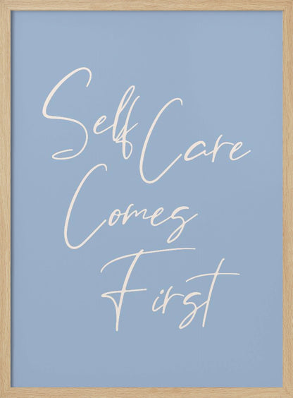A framed poster featuring the phrase 'Self Care Comes First' in an elegant, off-white cursive font against a solid light blue background. The artwork is enclosed in a simple black frame. Decor