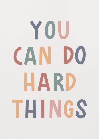 A framed poster featuring the inspirational quote 'YOU CAN DO HARD THINGS'. The text is in a simple, uppercase, sans-serif font with each letter in a different muted color, including shades of blue, green, pink, and orange, on a clean white background. Print