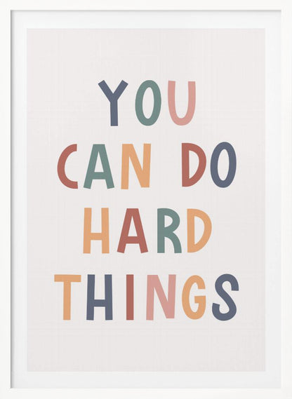 A framed poster featuring the inspirational quote 'YOU CAN DO HARD THINGS'. The text is in a simple, uppercase, sans-serif font with each letter in a different muted color, including shades of blue, green, pink, and orange, on a clean white background. Print