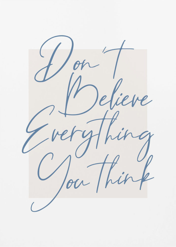 A minimalist art print in a black frame with the quote 'Don't Believe Everything You Think' written in blue cursive script. The text is set against a light beige rectangular background on a white canvas. Wall Art