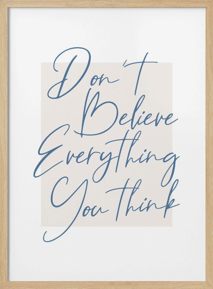 A minimalist art print in a black frame with the quote 'Don't Believe Everything You Think' written in blue cursive script. The text is set against a light beige rectangular background on a white canvas. Wall Art