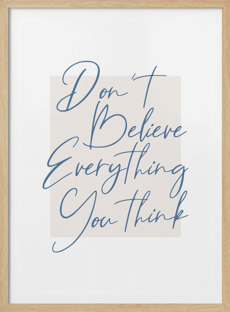 A minimalist art print in a black frame with the quote 'Don't Believe Everything You Think' written in blue cursive script. The text is set against a light beige rectangular background on a white canvas. Wall Art