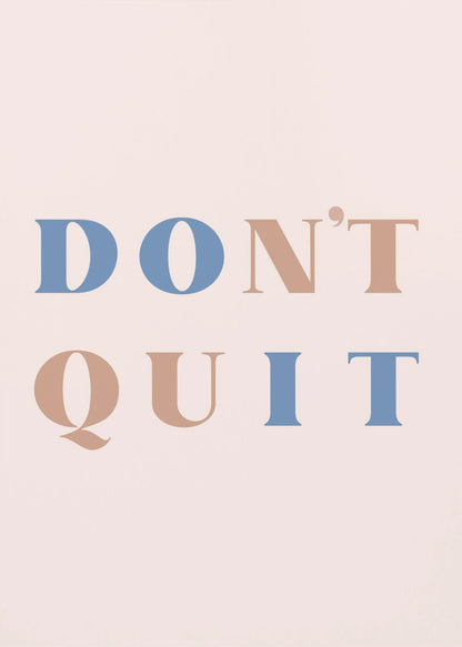 A minimalist motivational art print with a pale pink background and a thin black frame. The text reads 'DON'T QUIT' in a large serif font, with the words 'DO' and 'IT' highlighted in blue and the words 'N'T' and 'QU' in a muted terracotta color, creating a hidden 'DO IT' message. Decor