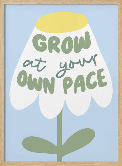 A motivational art print featuring a stylized white flower with a yellow center and green stem against a light blue background. The phrase 'GROW at your OWN PACE' is written in green, hand-drawn lettering across the flower's petals. Artwork