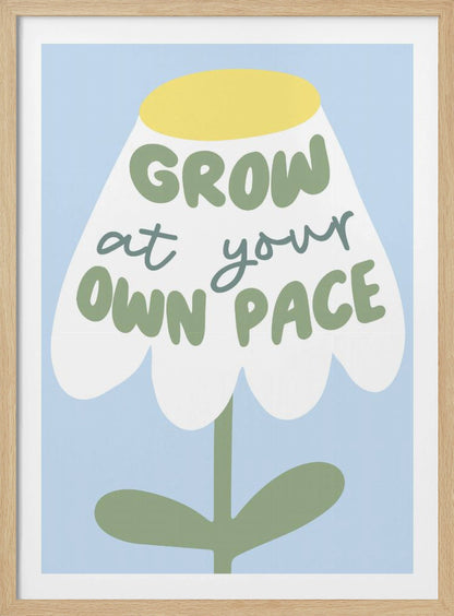A motivational art print featuring a stylized white flower with a yellow center and green stem against a light blue background. The phrase 'GROW at your OWN PACE' is written in green, hand-drawn lettering across the flower's petals. Artwork