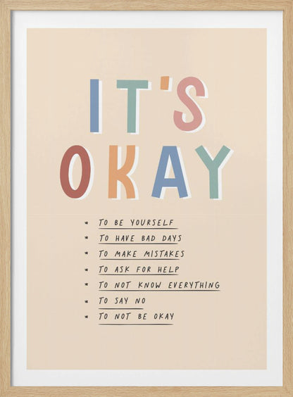 An inspirational framed poster with the words 'IT'S OKAY' in large, colorful letters. Below is a list of affirmations including 'TO BE YOURSELF', 'TO HAVE BAD DAYS', and 'TO MAKE MISTAKES' on a beige background. Artwork