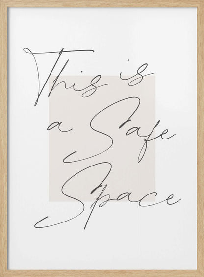 A minimalist art print in a black frame with the words 'This is a Safe Space' written in a flowing black cursive script over a pale beige rectangle on a white background. Artwork