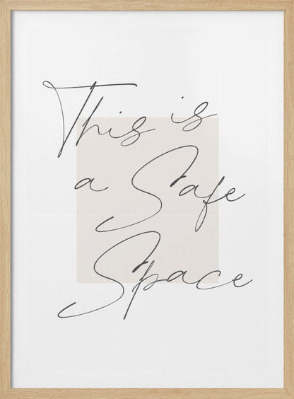 A minimalist art print in a black frame with the words 'This is a Safe Space' written in a flowing black cursive script over a pale beige rectangle on a white background. Artwork