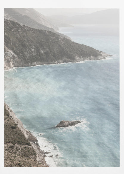 A high-angle photograph of a rugged, green coastline meeting a misty, light-blue ocean. The hazy atmosphere softens the view of the distant mountains and the waves crashing against the rocky shores. Poster